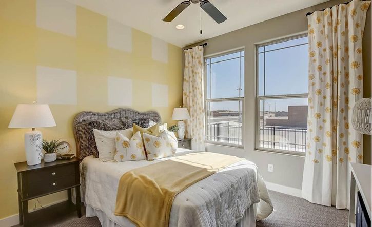 Sophisticated wicker headboard and bright yellow accents define this Castillo bedroom at Anderson Parc.