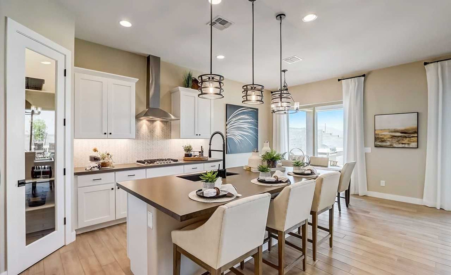 This Canyon Views kitchen boasts bespoke cabinetry, sleek countertops, and refined pendant lighting.