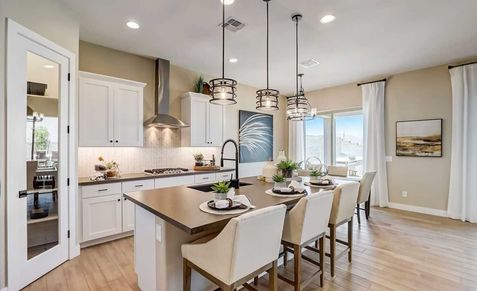 This Canyon Views kitchen boasts bespoke cabinetry, sleek countertops, and refined pendant lighting.