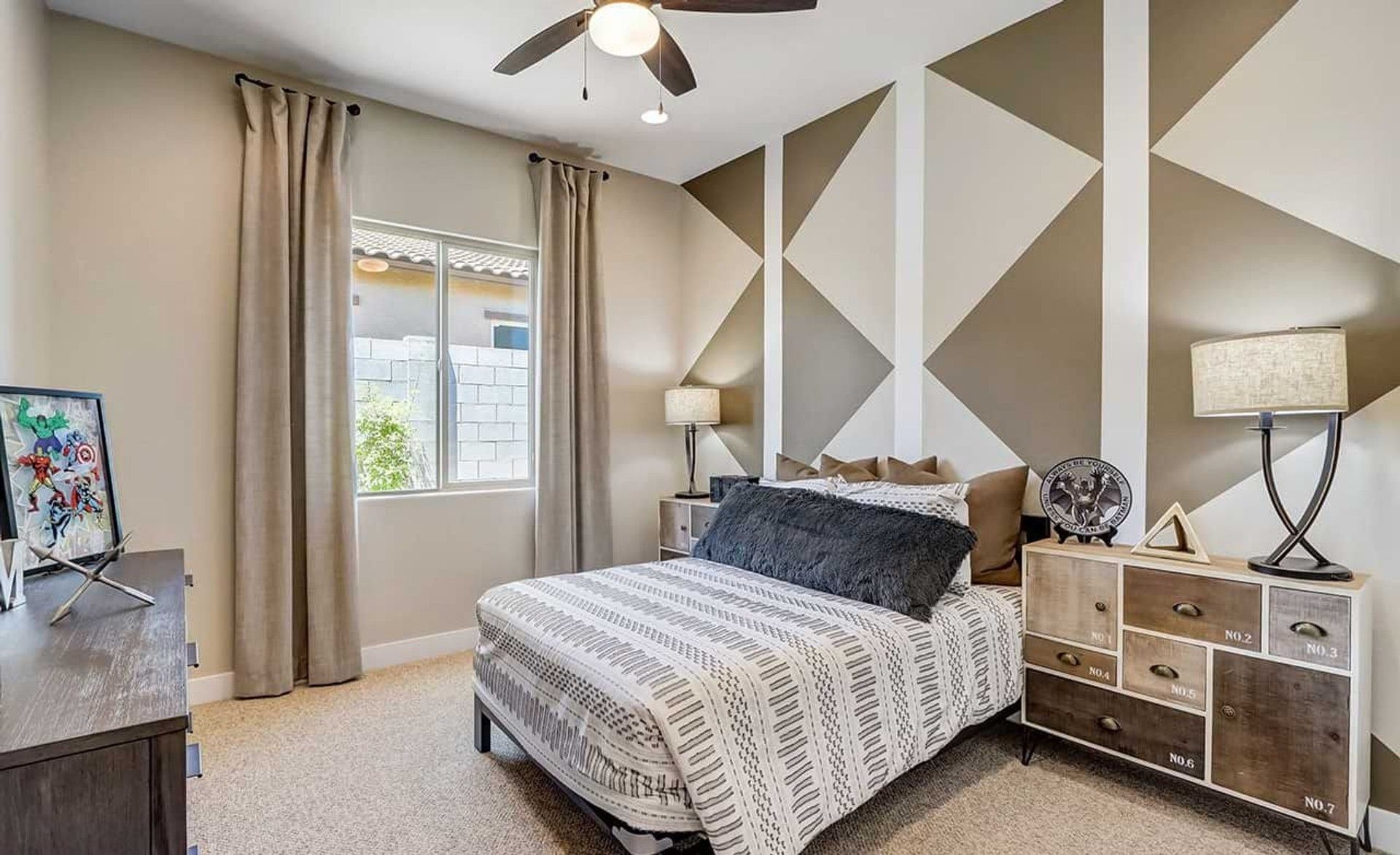 Geometric wall design and bespoke furniture elevate this Hacienda community bedroom's appeal.