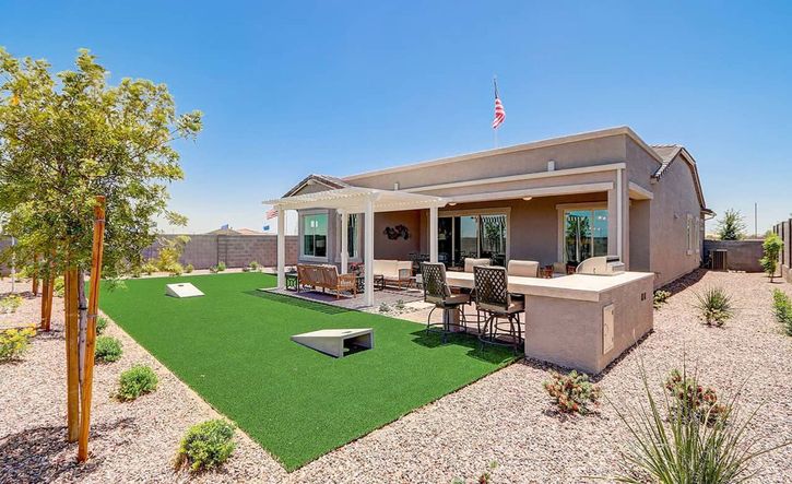 Elegant outdoor living with premium stone patio and pergola in the Arizona desert's Hacienda community.