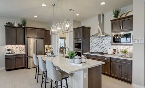 Exquisite kitchen with quartz island, stainless steel appliances, and elegant pendant lights in Canyon Views Hacienda.