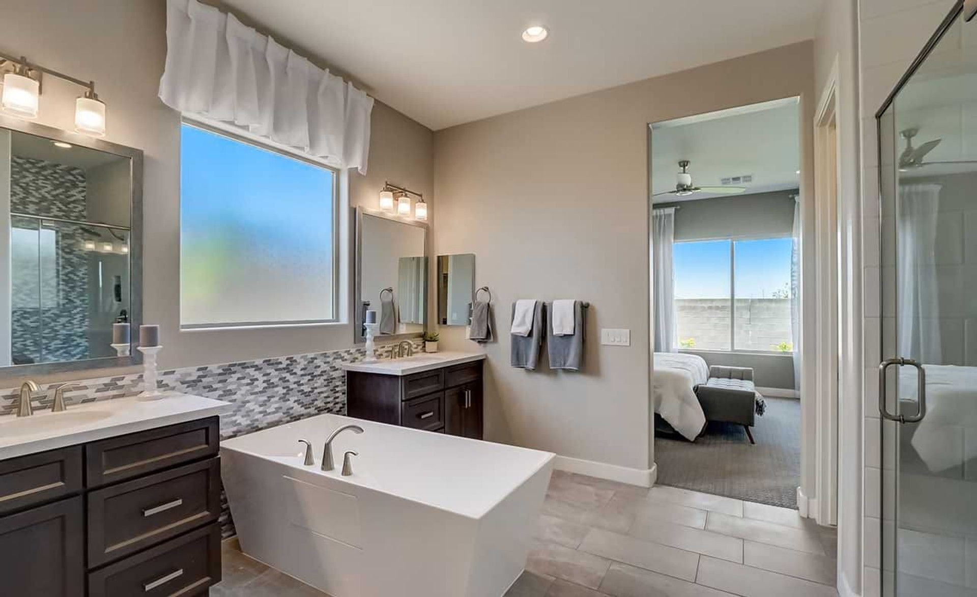 Exquisite freestanding tub and dark wood cabinetry in a serene Hacienda community bathroom.