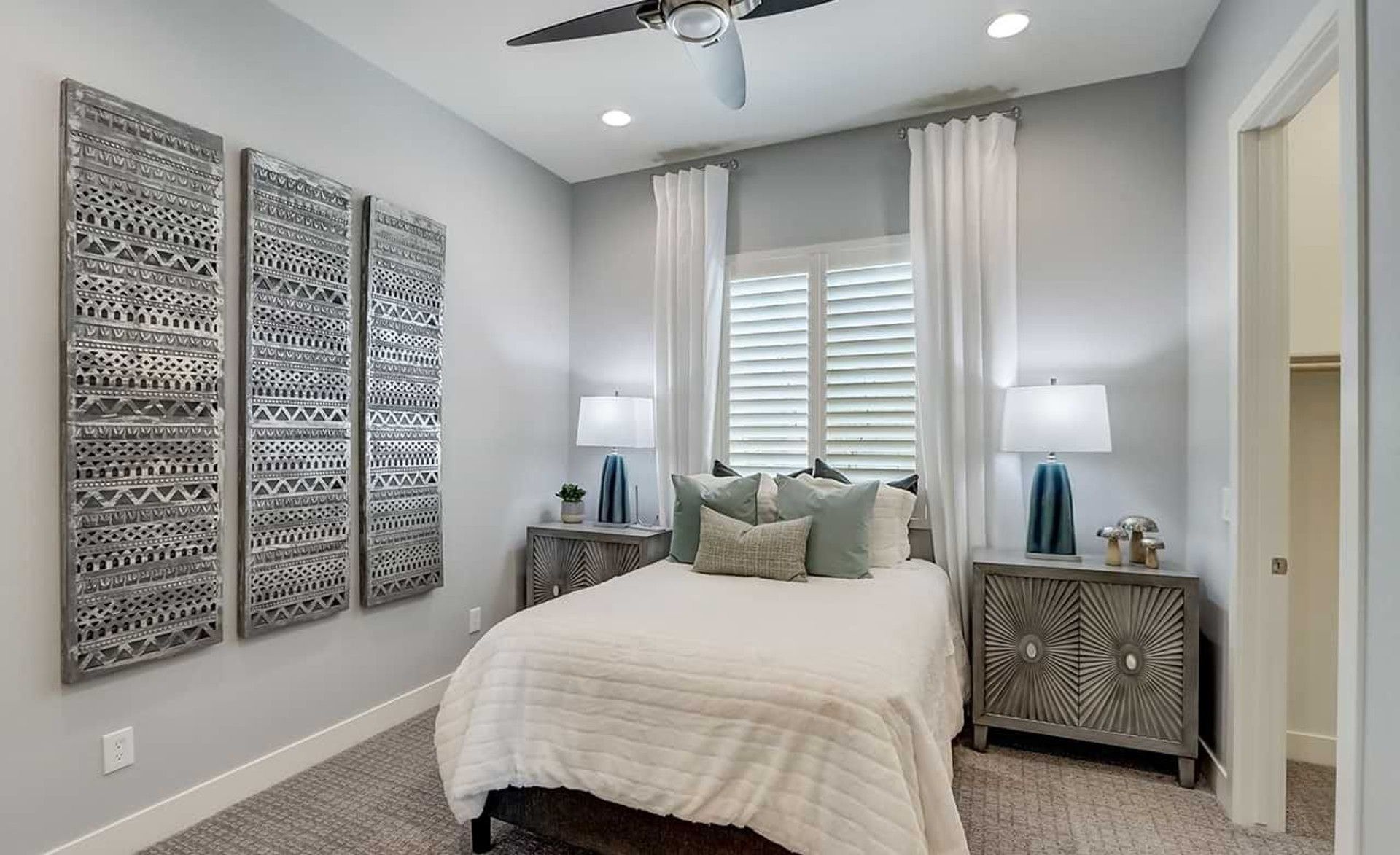 Elegant Hacienda bedroom with artisanal wall art, plush bedding, and contemporary nightstands.