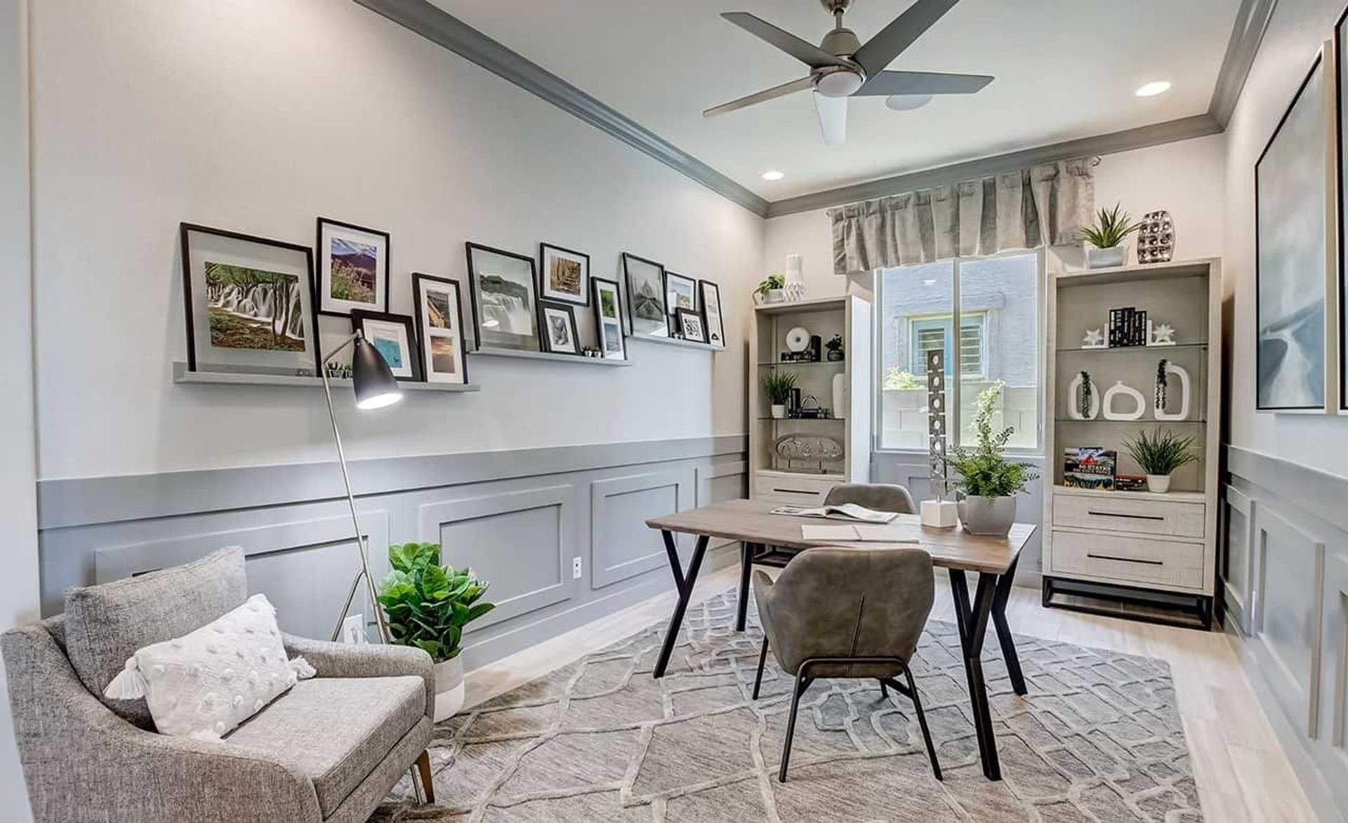 Elegant home office in Mirada Crossing featuring chic gray paneling, stylish decor, and abundant natural light.