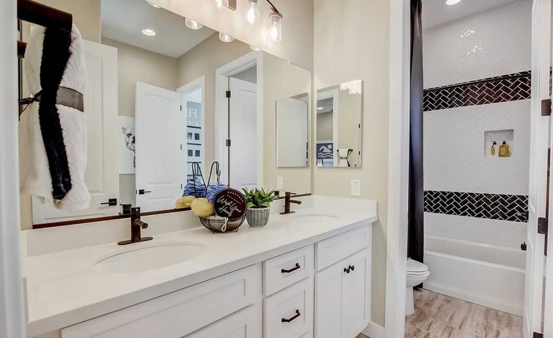 Sophisticated double vanity and exquisite tile in Mirada Crossing create an inviting, modern ambiance.