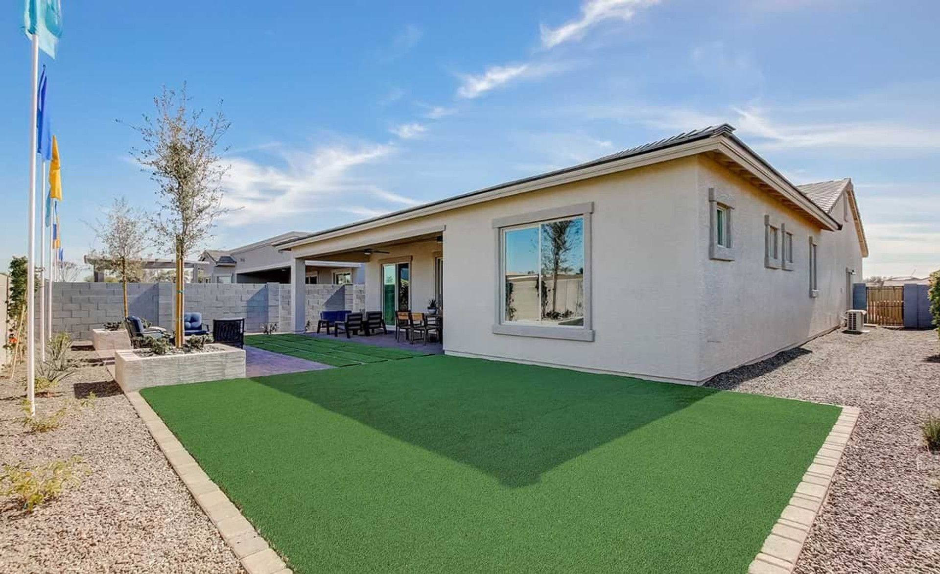 Luxury home in Mirada Crossing features a sleek patio and lush synthetic lawn, offering a serene Arizona retreat.