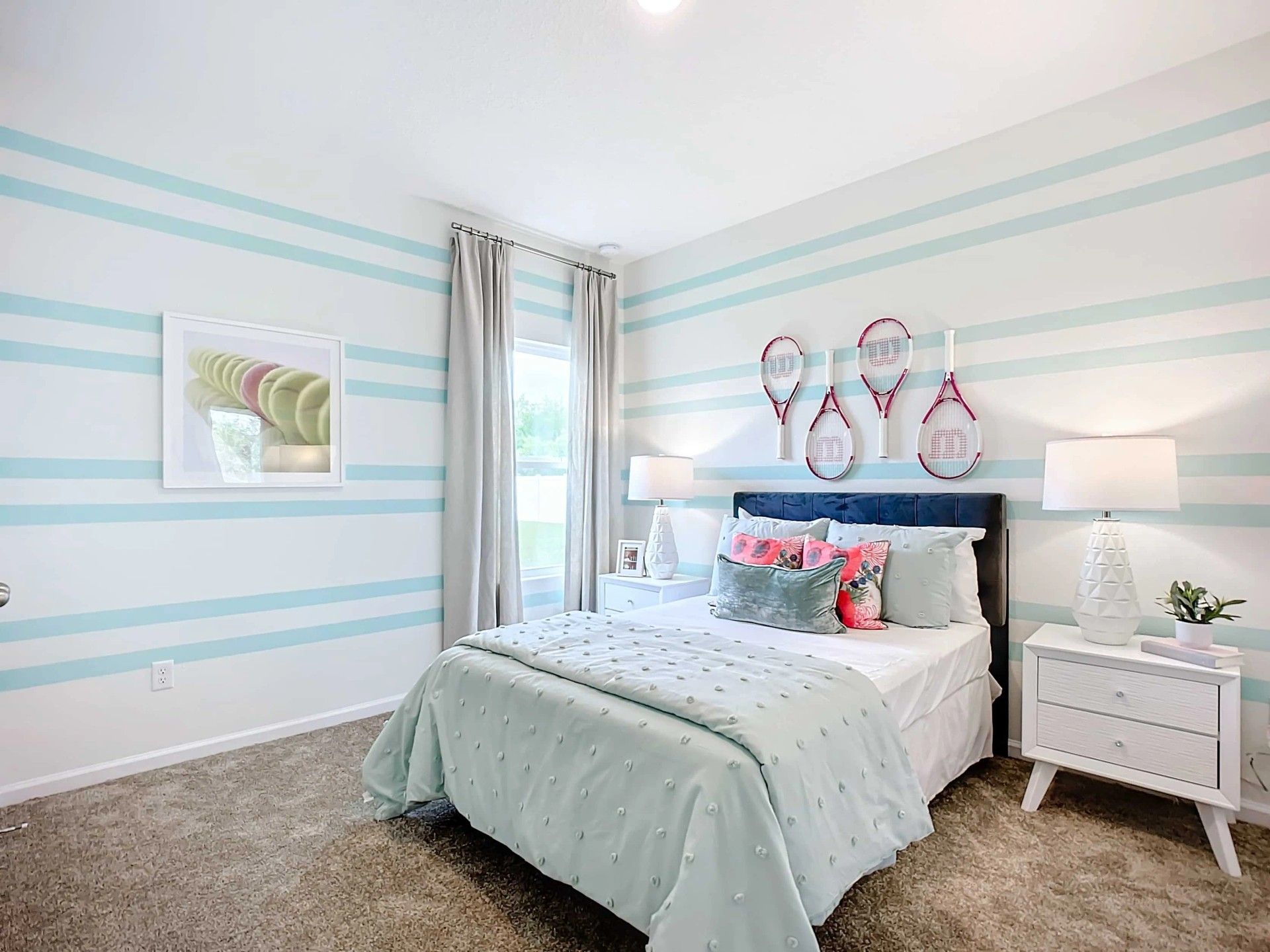 Elegant blue-striped walls and chic tennis theme elevate this Panther Creek bedroom in Jacksonville.