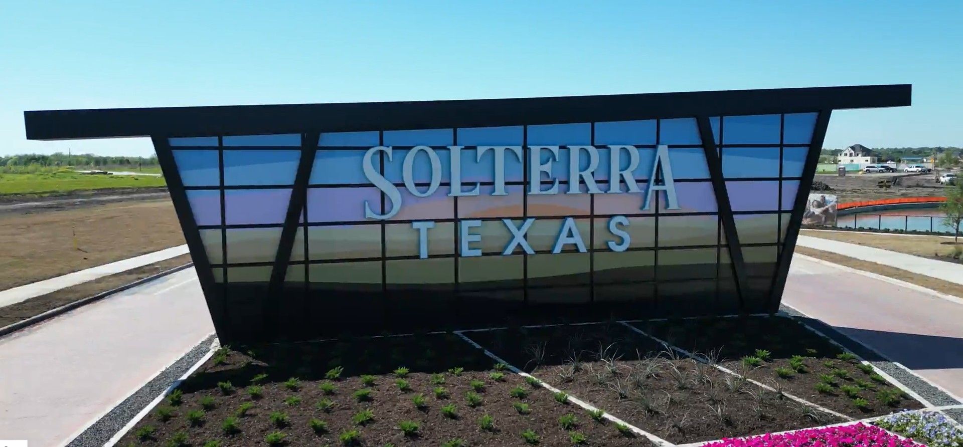 Experience Solterra Texas: Modern architecture with angular glass design, surrounded by lush landscaping.