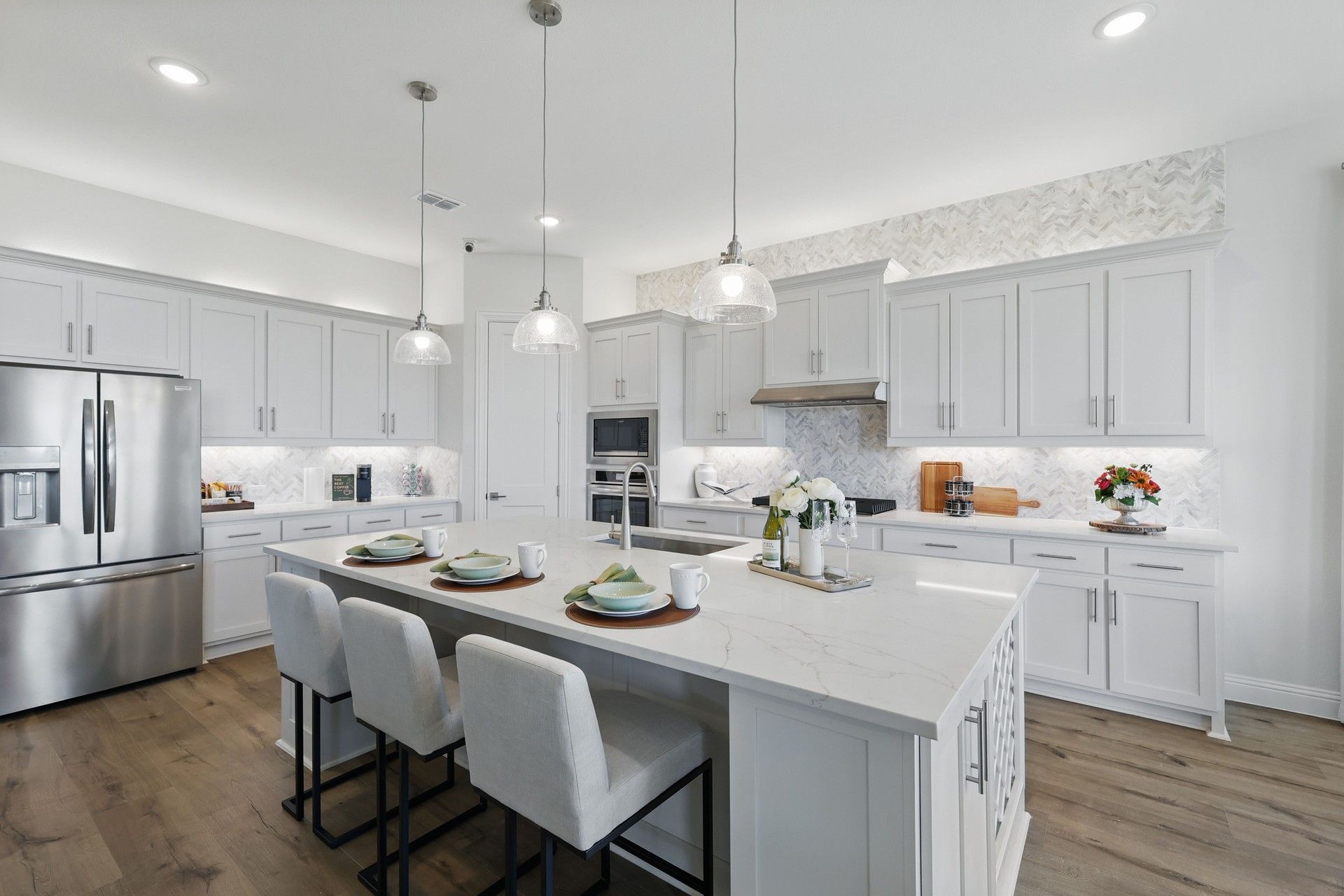 Luxurious marble island and herringbone backsplash define this Rio Vista kitchen's elegance.