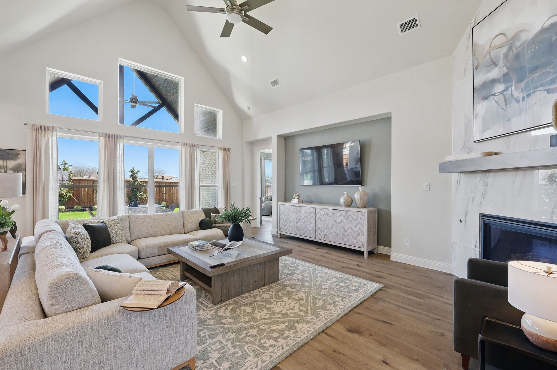 Luxurious living room features vaulted ceilings, elegant fireplace, and chic decor. Rio Vista at Kelly Ranch.