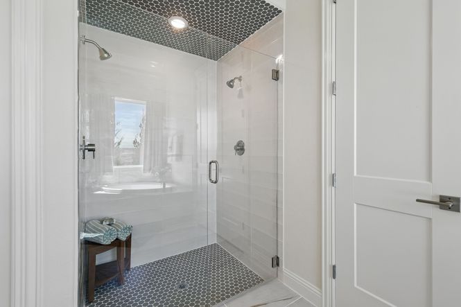 Sophisticated shower with hexagonal tiles and premium fixtures in Kelly Ranch’s Rio Vista enclave.