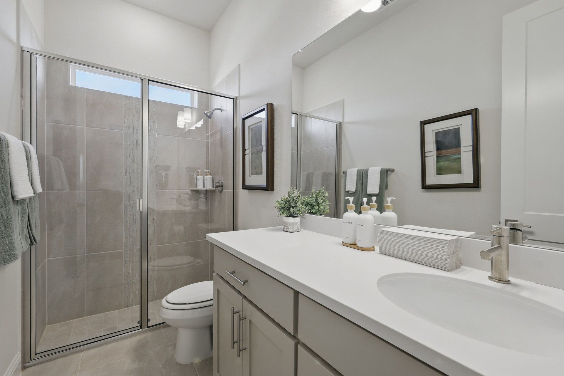 Luxuriously designed with a pristine white vanity and sleek glass shower at Rio Vista, Kelly Ranch.