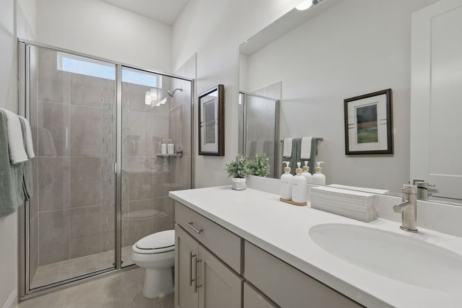 Luxuriously designed with a pristine white vanity and sleek glass shower at Rio Vista, Kelly Ranch.
