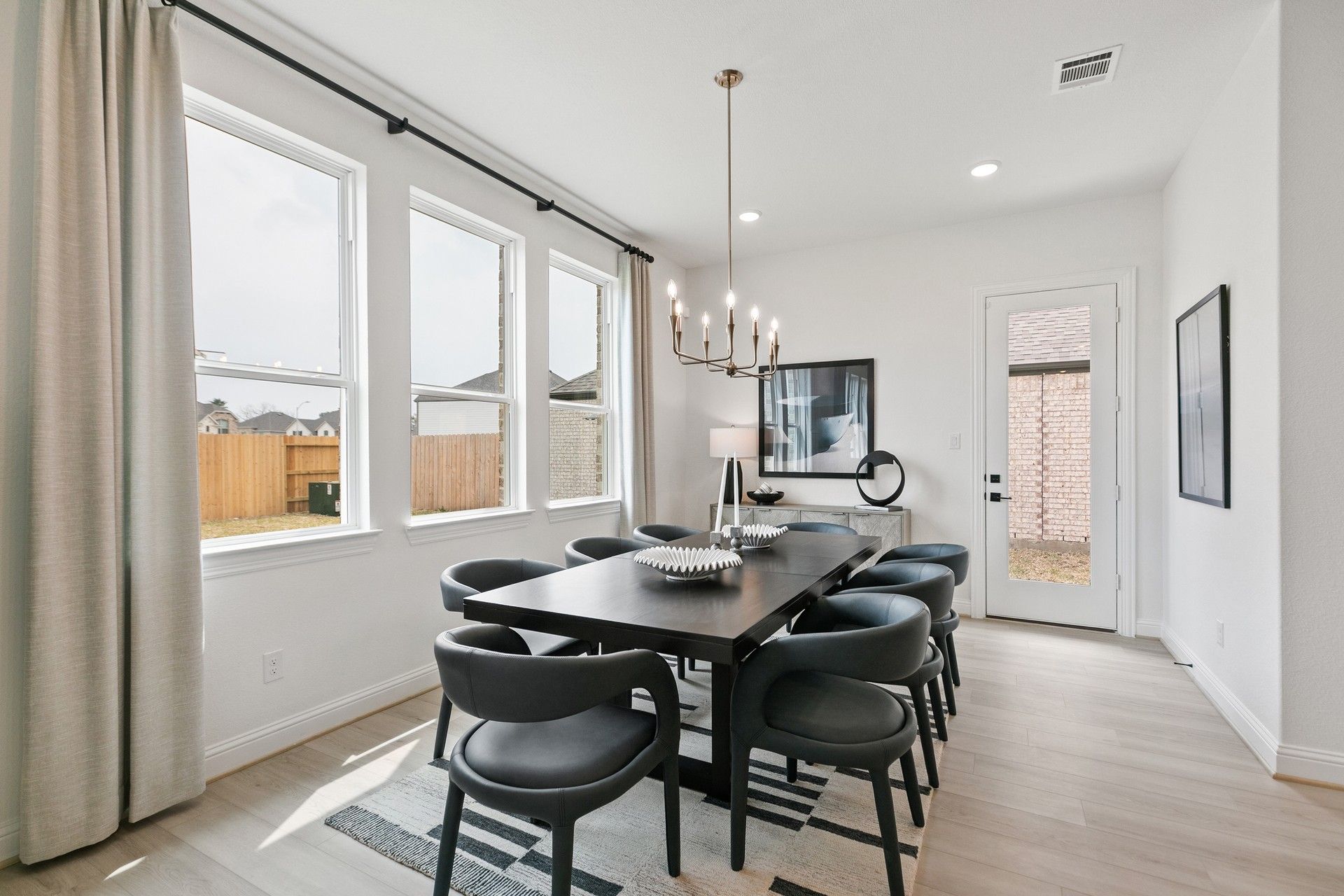 Sophisticated dining space features elegant chandelier and large windows, highlighting Houston's Park at Eldridge luxury.