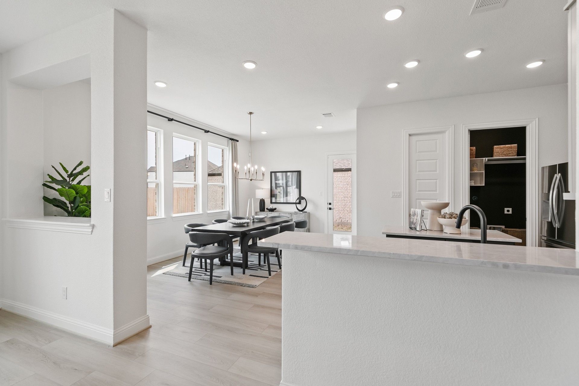 Luxurious open-plan dining with elegant chandelier and premium hardwood floors in Park at Eldridge, Houston.