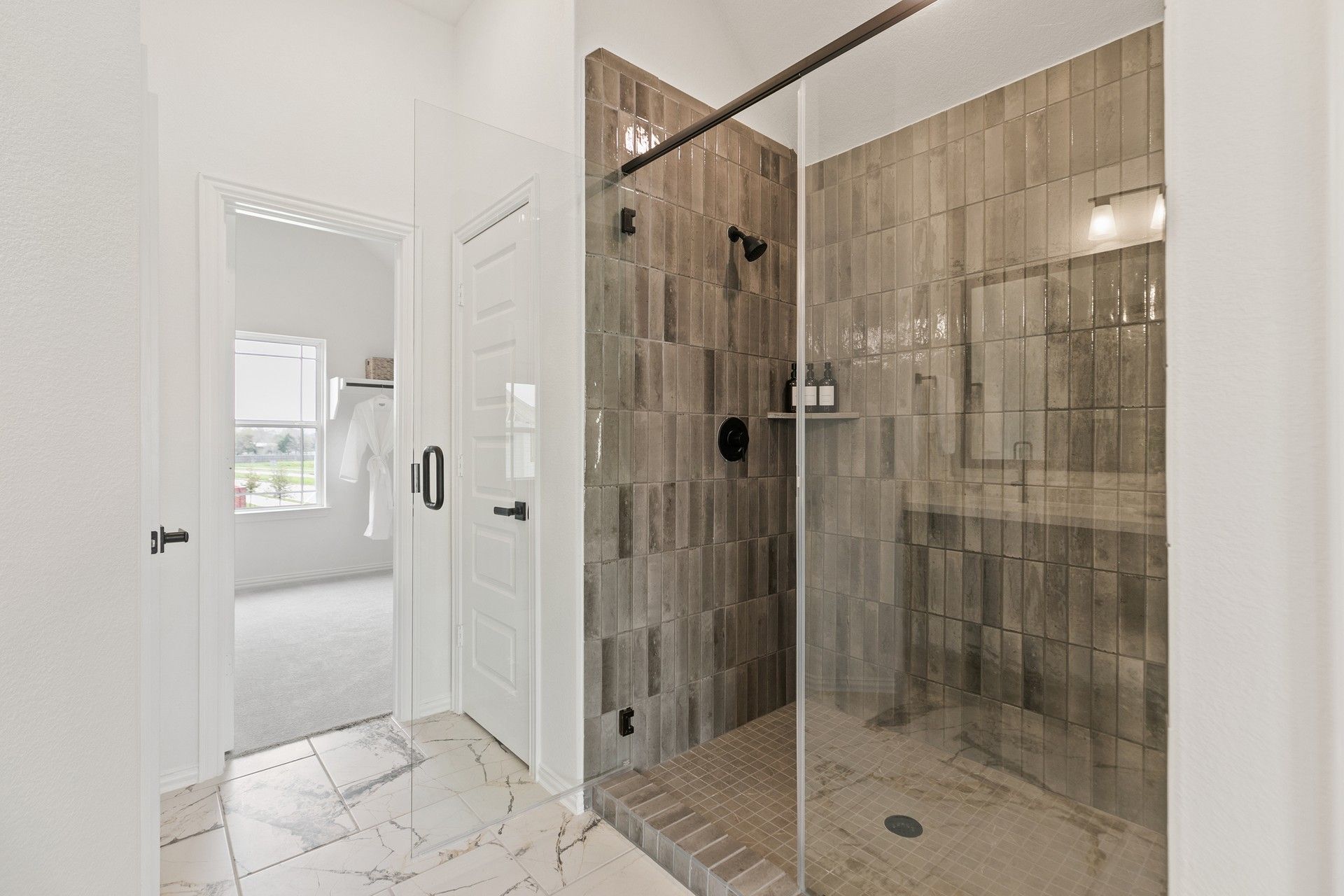 Exquisite brown tile shower with sleek glass door in Park at Eldridge, offering modern elegance.