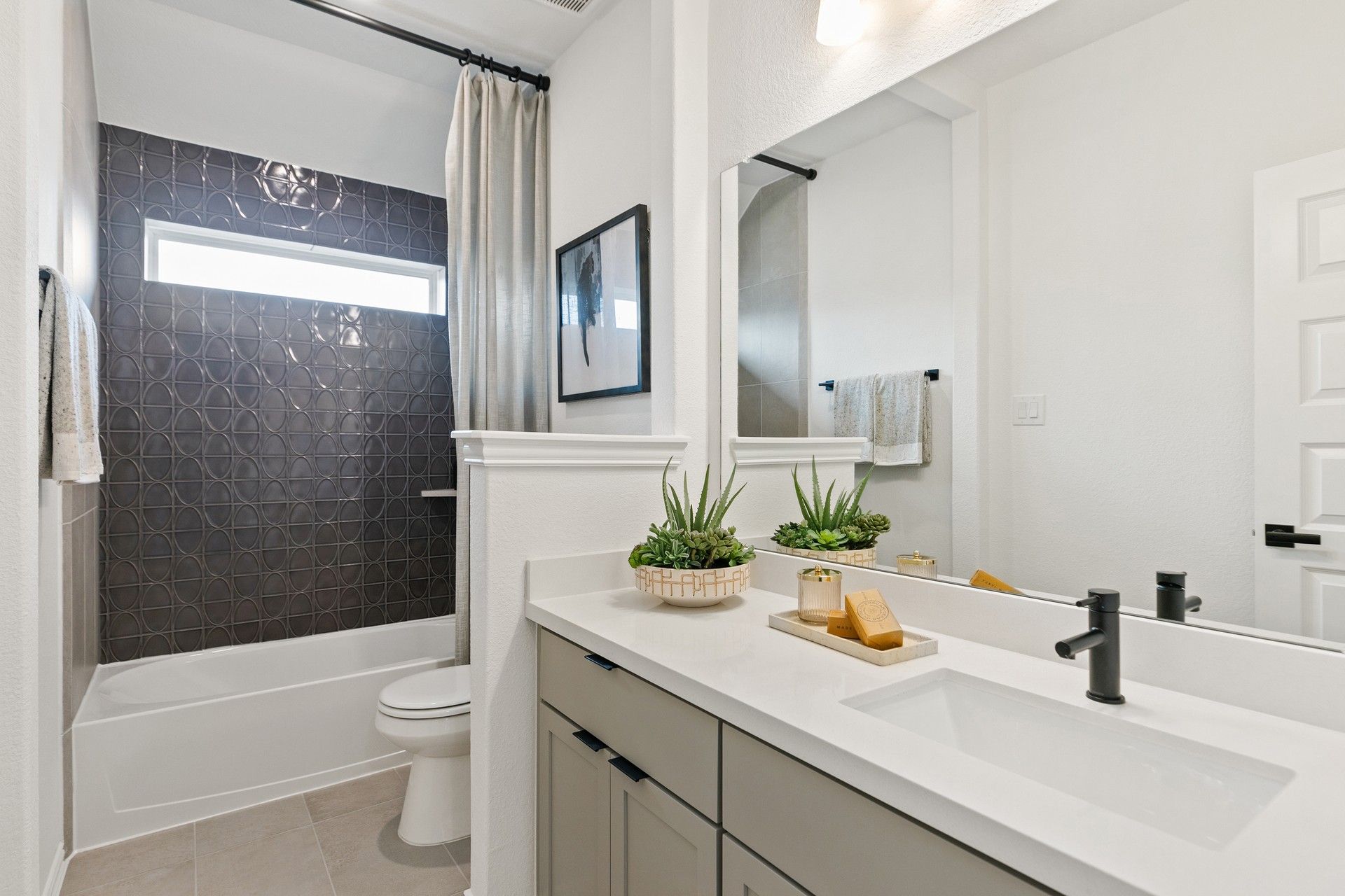 Luxurious bathroom features geometric tile and sleek design elements in Park at Eldridge.