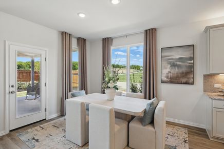 Sleek dining space with plush seating, artful accents, and abundant natural light in Green Oaks Preserve.