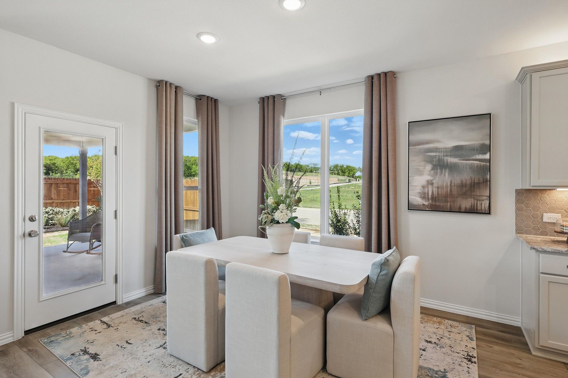 Sleek dining space with plush seating, artful accents, and abundant natural light in Green Oaks Preserve.