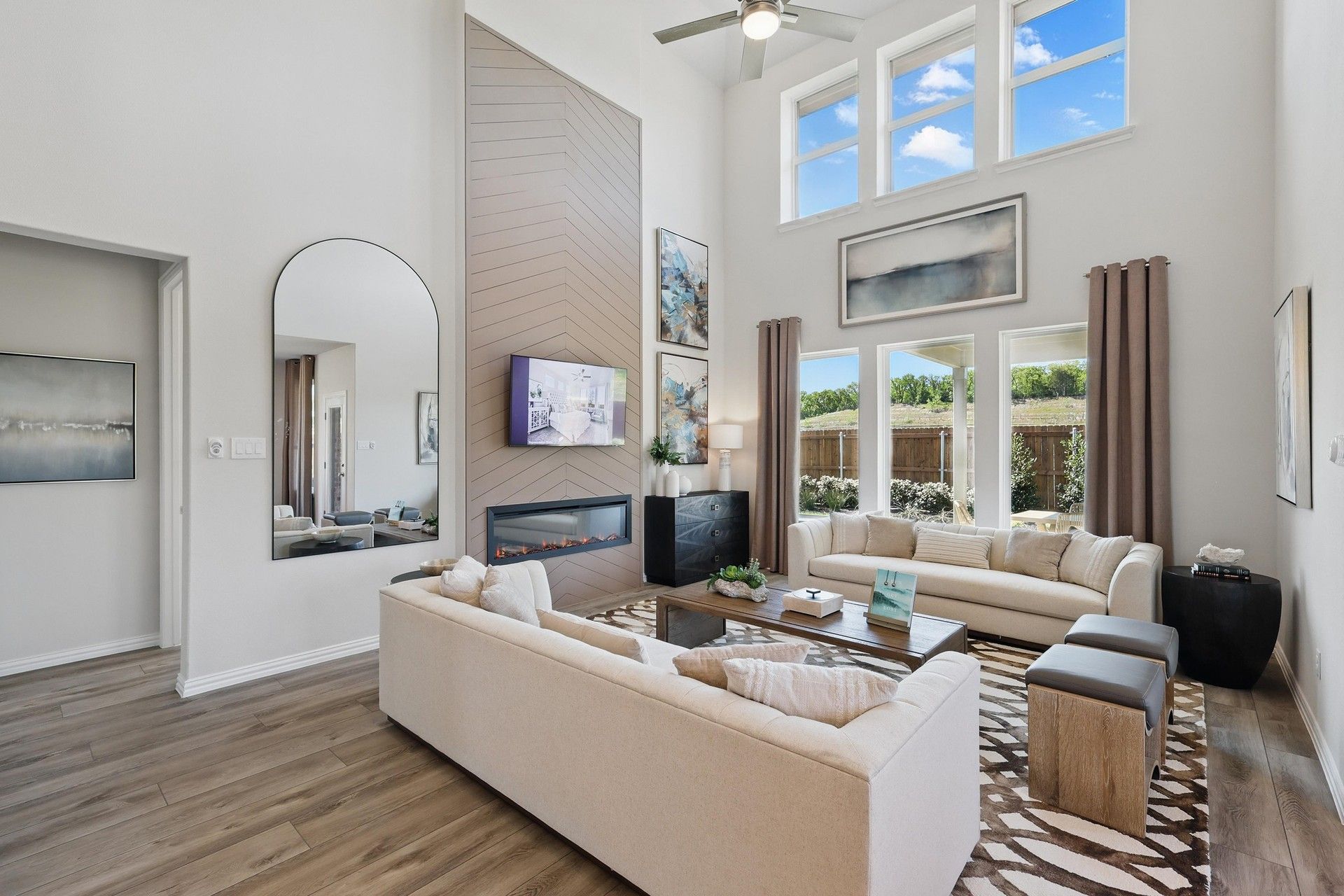 Soaring ceilings and expansive windows elevate this Green Oaks Preserve living area with elegant design touches.