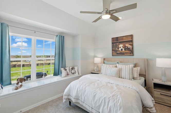 Sophisticated bedroom boasts plush textures, expansive window, and tranquil views in Green Oaks Preserve.