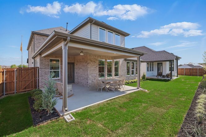 Elegant brick exterior and spacious patio enhance luxury in Green Oaks Preserve.