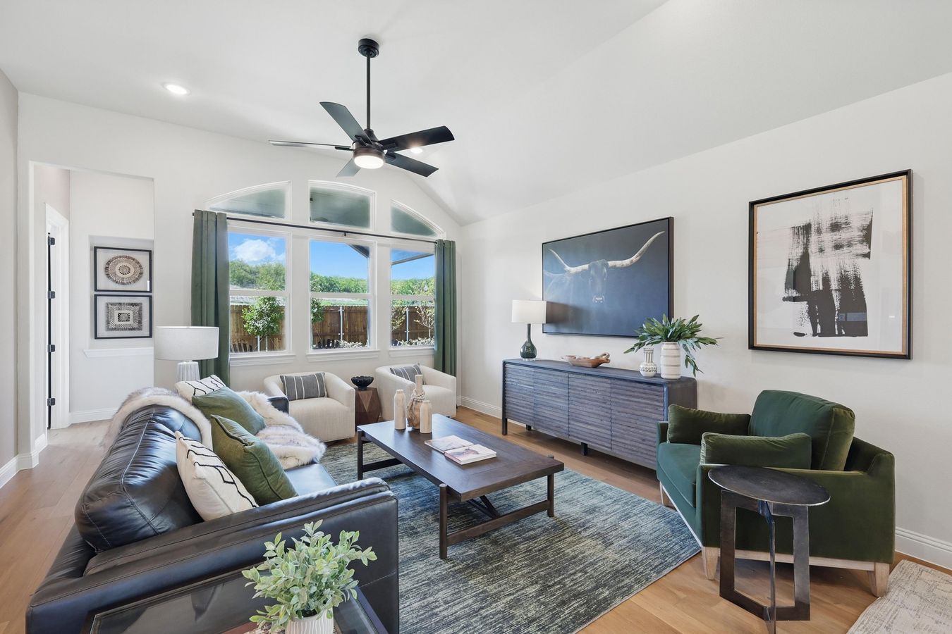 Experience sophistication with vaulted ceilings and arched windows in Green Oaks Preserve’s modern living area.