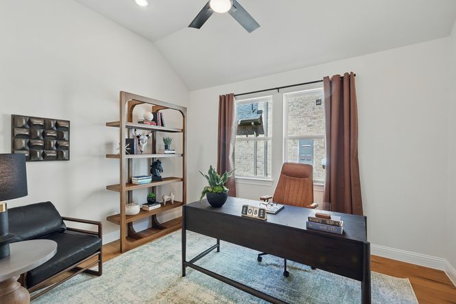 Luxurious office with vaulted ceiling and oak flooring, blending elegance and functionality in Green Oaks Preserve.