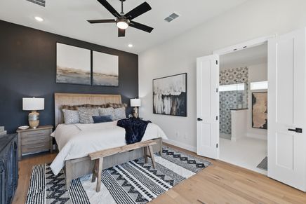 Luxurious bedroom with bespoke wood accents and chic ensuite bathroom in Green Oaks Preserve.