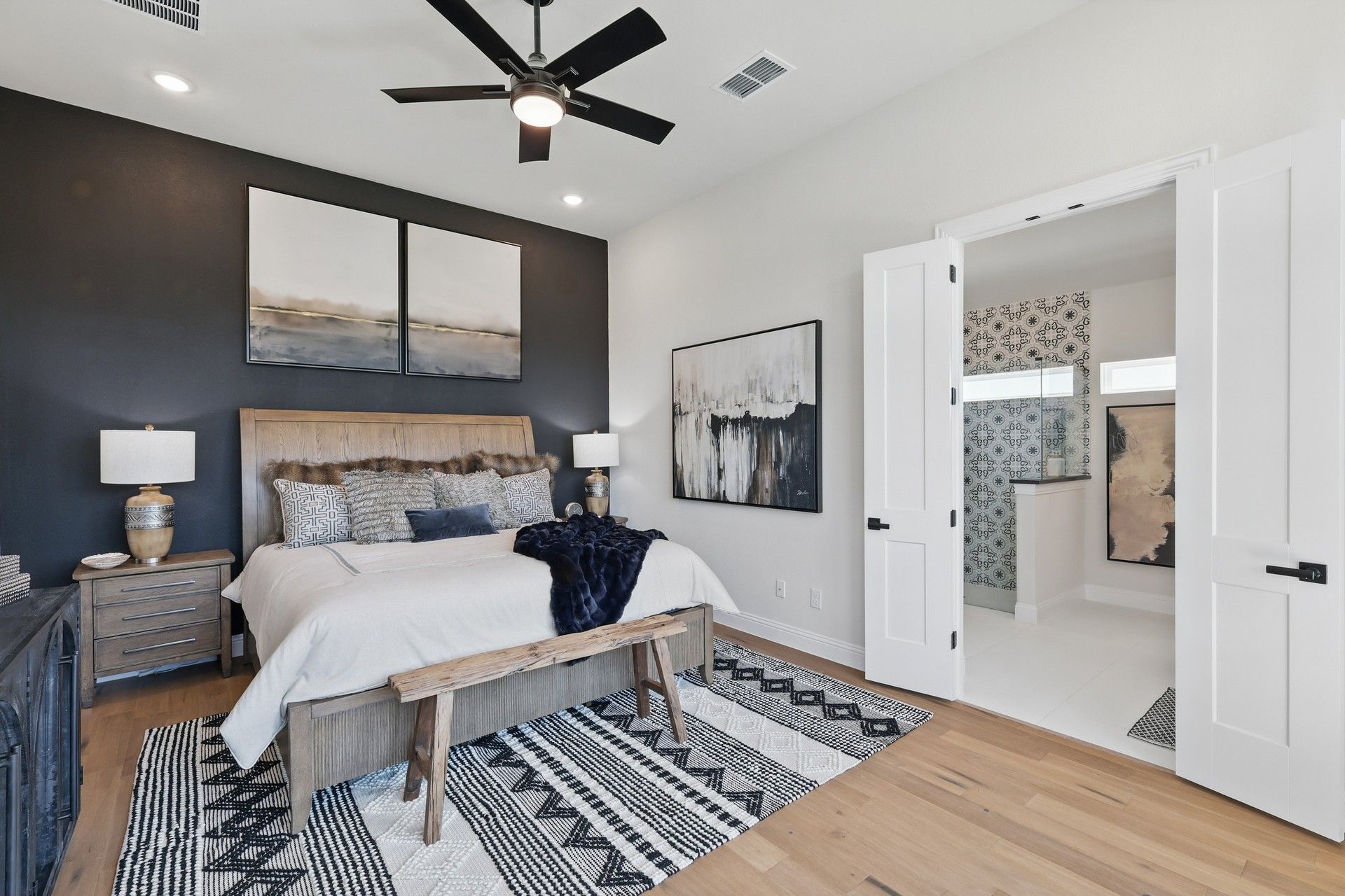 Luxurious bedroom with bespoke wood accents and chic ensuite bathroom in Green Oaks Preserve.