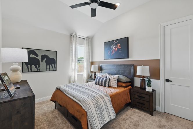 Experience vaulted ceilings and tasteful horse artwork in this refined Green Oaks Preserve bedroom.