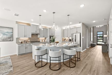 Marvel at the marble island, chic cabinetry, and exquisite pendant lighting in Green Oaks Preserve.