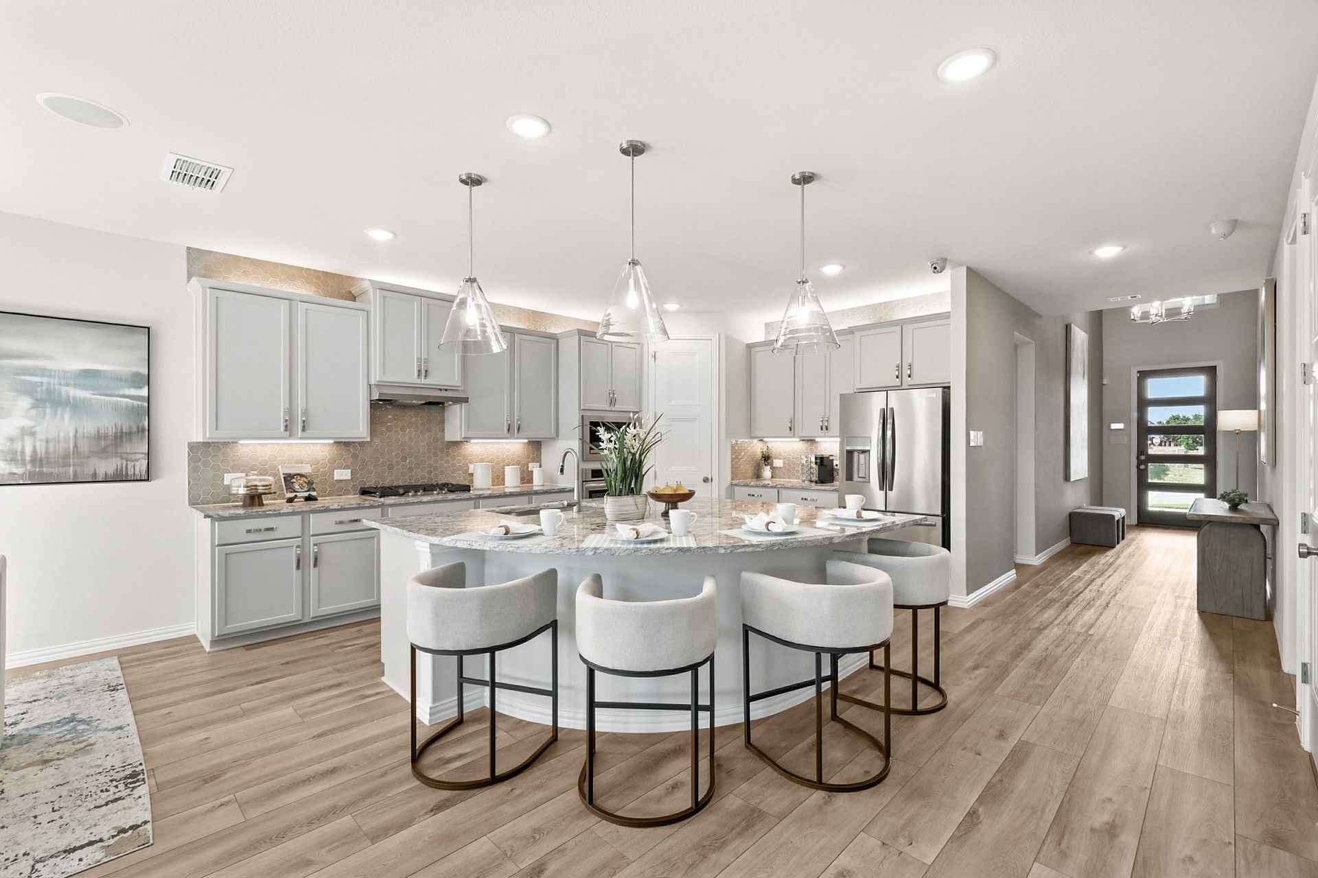 Marvel at the marble island, chic cabinetry, and exquisite pendant lighting in Green Oaks Preserve.