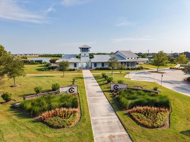 Elegant clubhouse with sleek metal roofing and manicured gardens in League City, TX.