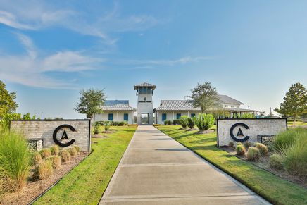 Elegant clubhouse with sleek metal roofing and manicured gardens in League City, Texas.