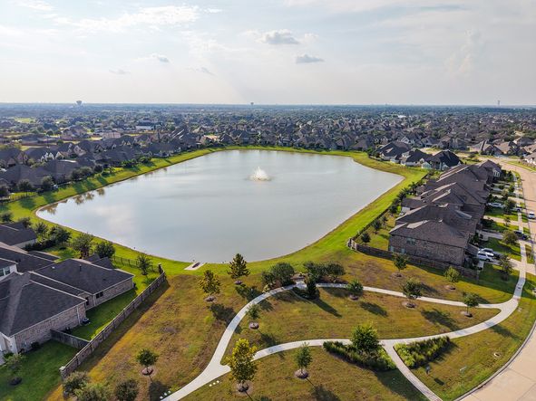 Elegant homes surround a tranquil pond with scenic walking trails in League City, Texas.