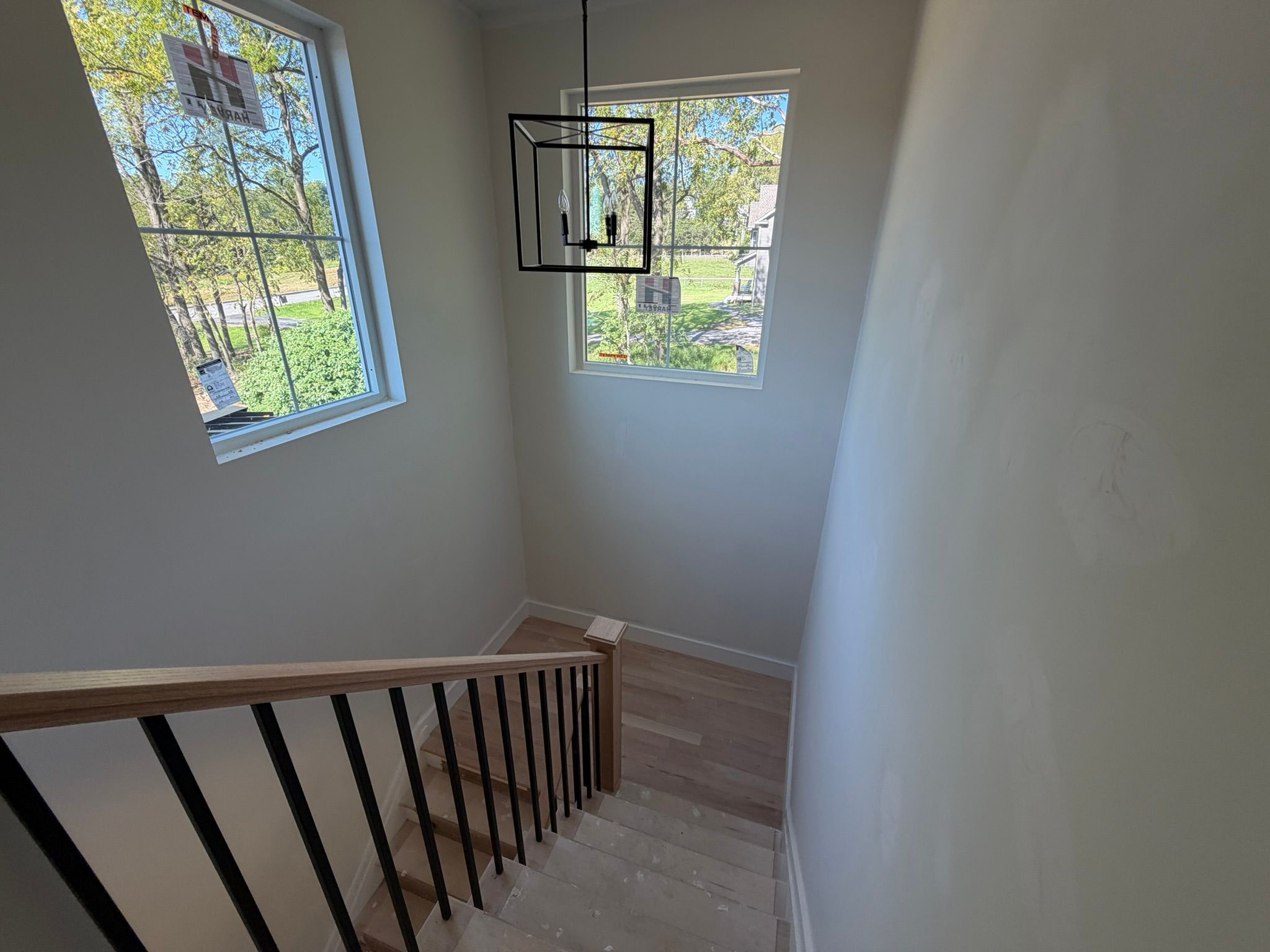 Construction Progress Photo Featuring Newly Installed Light Fixture, Windows and Stairs. 