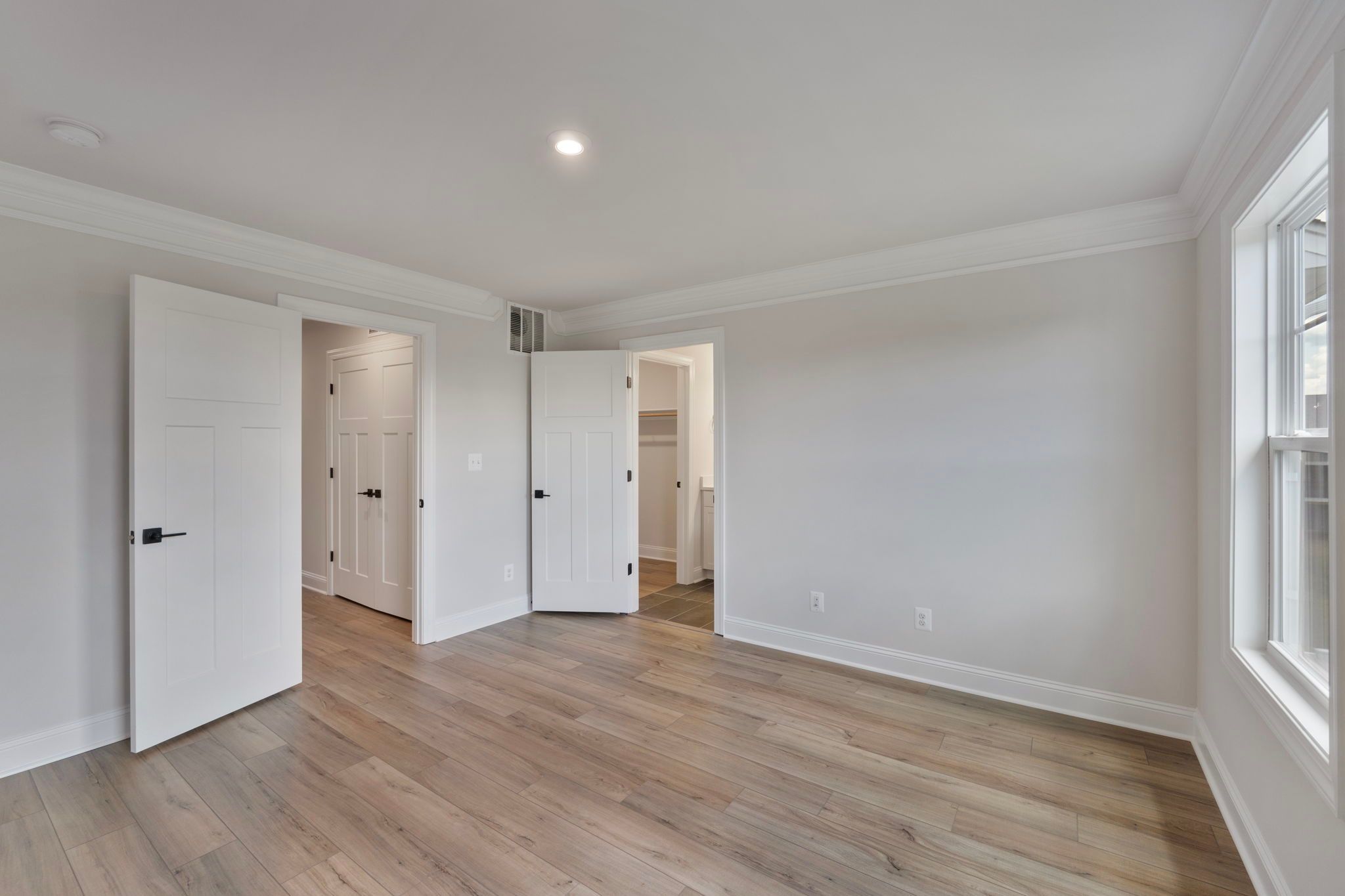 Primary bedroom with view into bath and walk-in closet - similar to photo