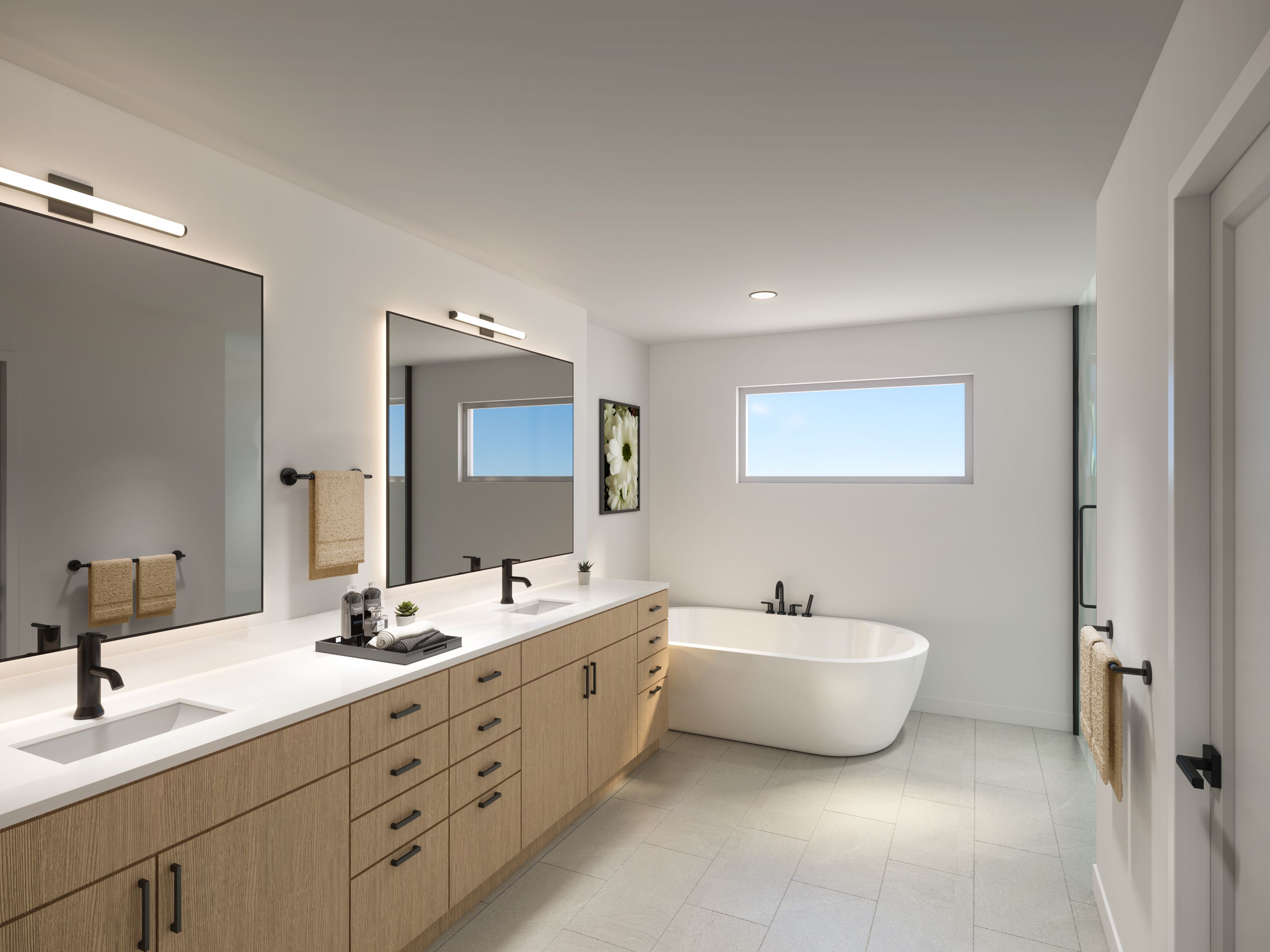 A spacious primary bathroom creates a serene retreat with a long double vanity and generous soaking tub. Shown here: Glacier and Elevation.