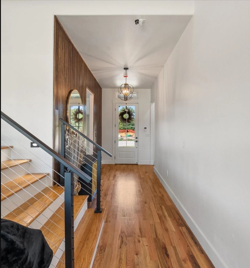 Entryway with a real wood feature wall with red oak wood floors.