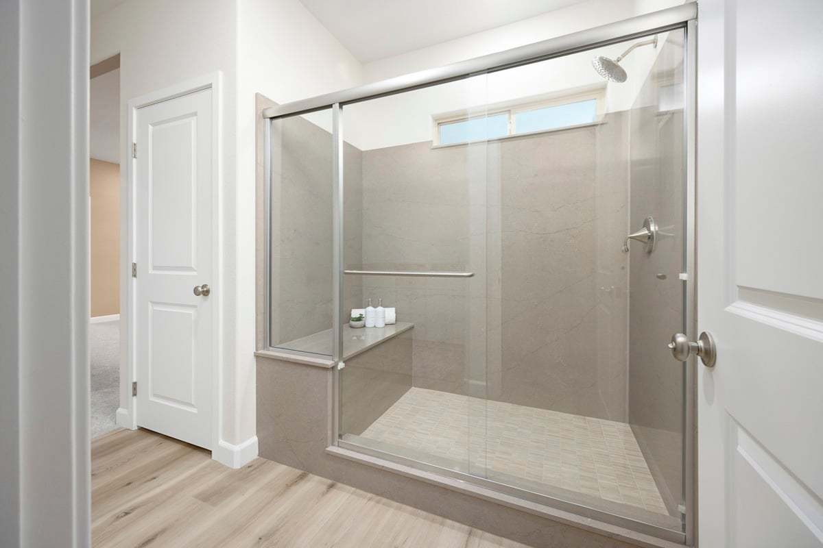 Enlarged walk-in shower with seat at primary bath