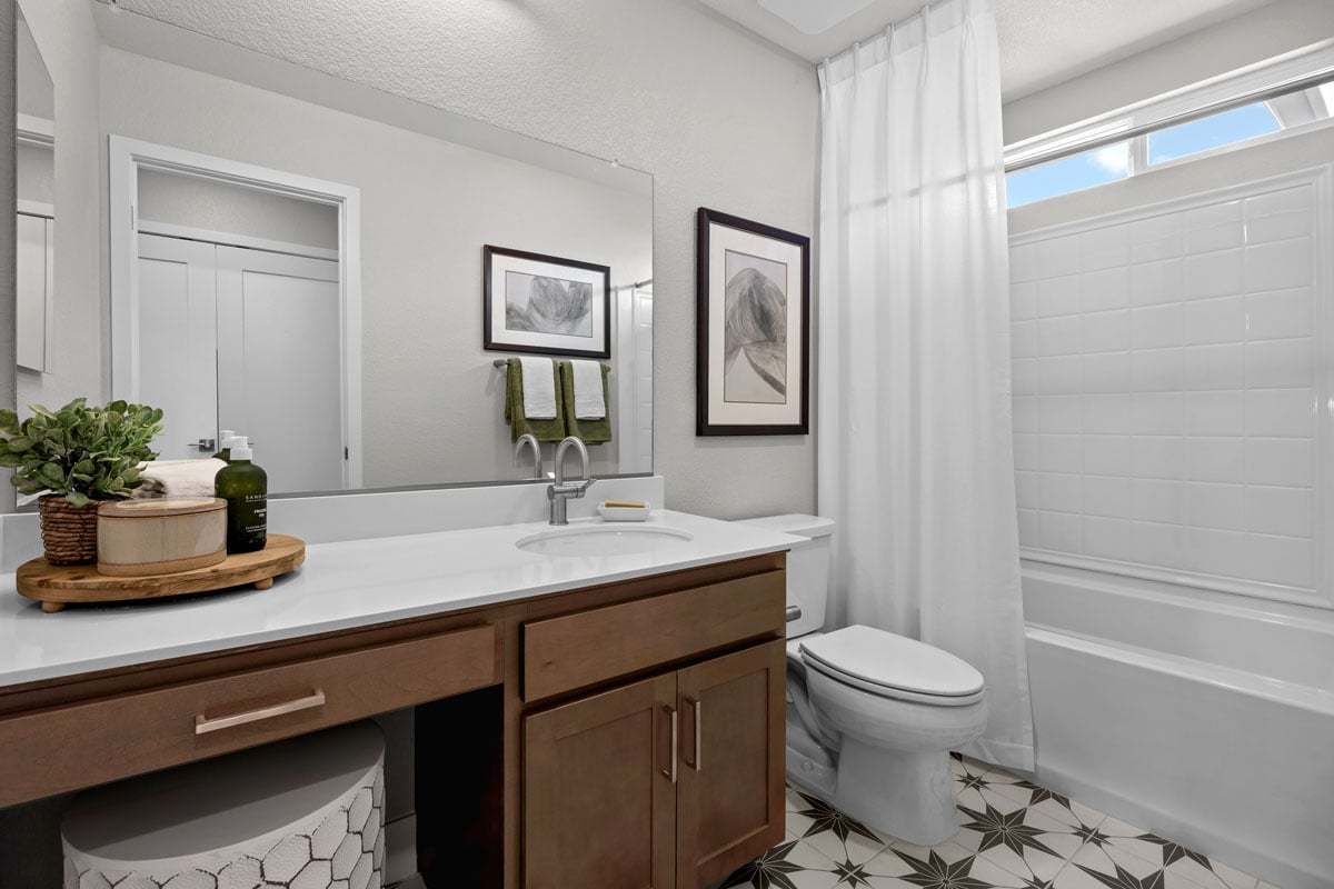 Plan 1652 Modeled - Extended vanity with maple cabinets and knee space at secondary bath