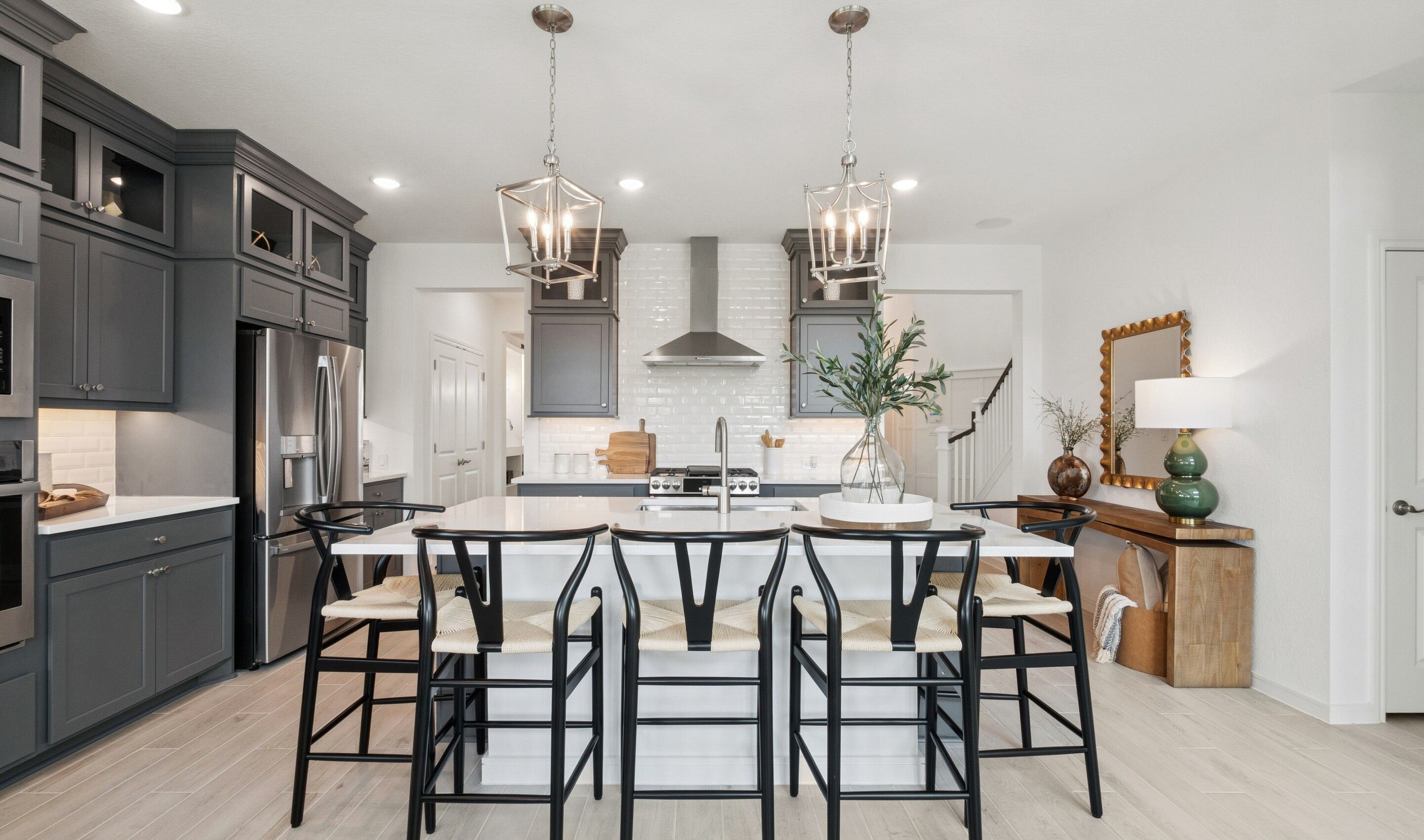 Kitchen showcases stacked cabinetry with glass-front uppers