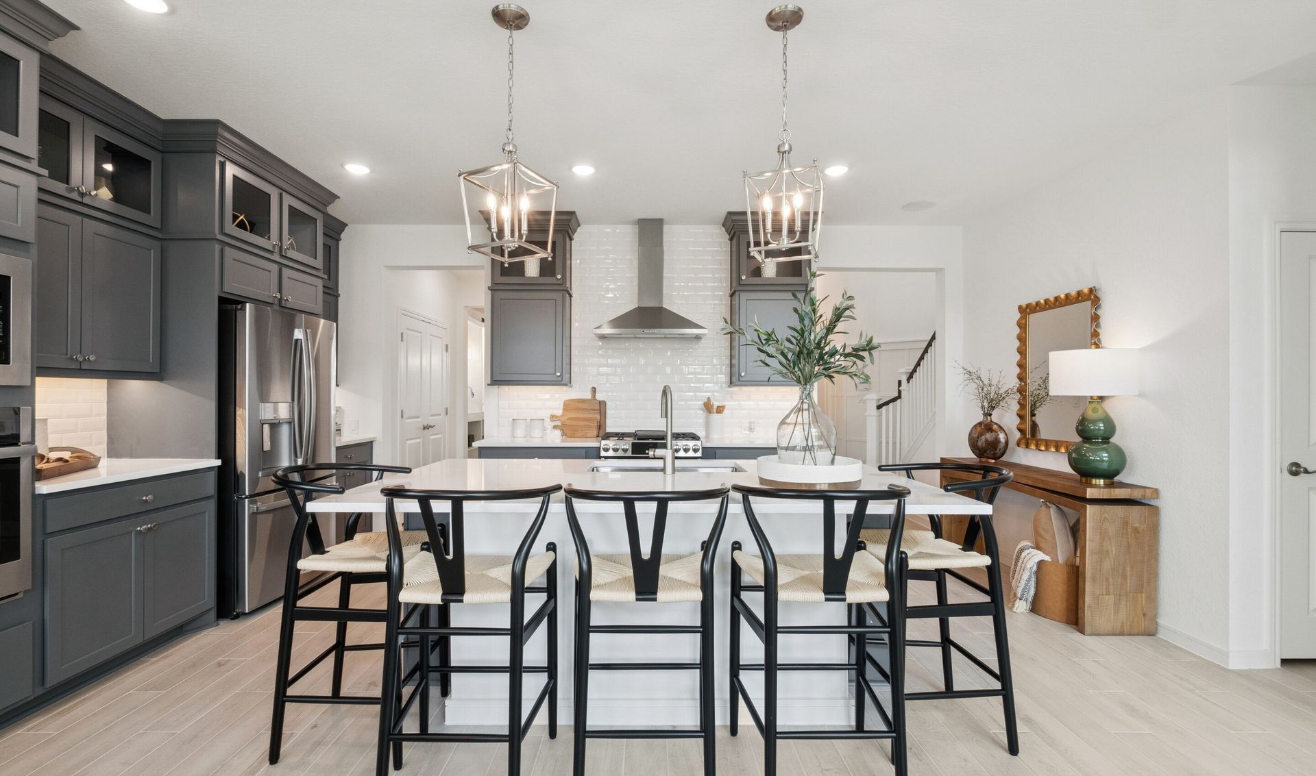 Kitchen showcases stacked cabinetry with glass-front uppers