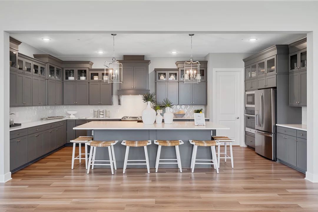 Kitchen with island, pendant lighting and glass-front upper cabinets