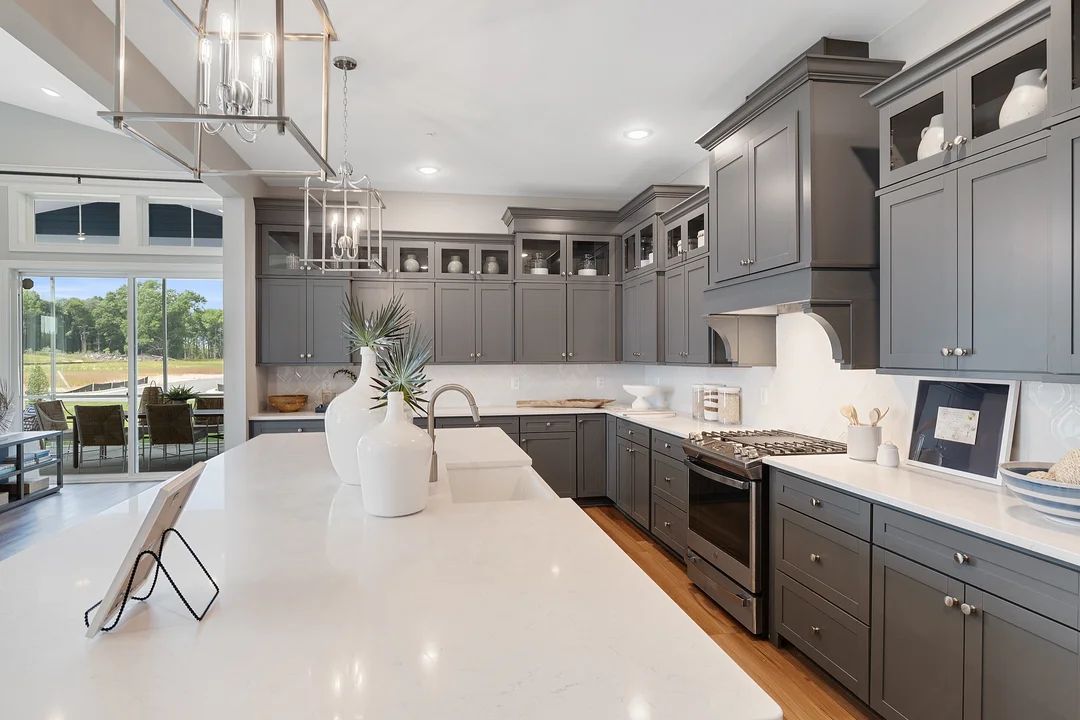 Kitchen with island, pendant lighting and glass-front upper cabinets