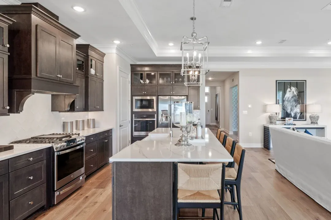 Kitchen with island, pendant lighting and glass-front upper cabinets