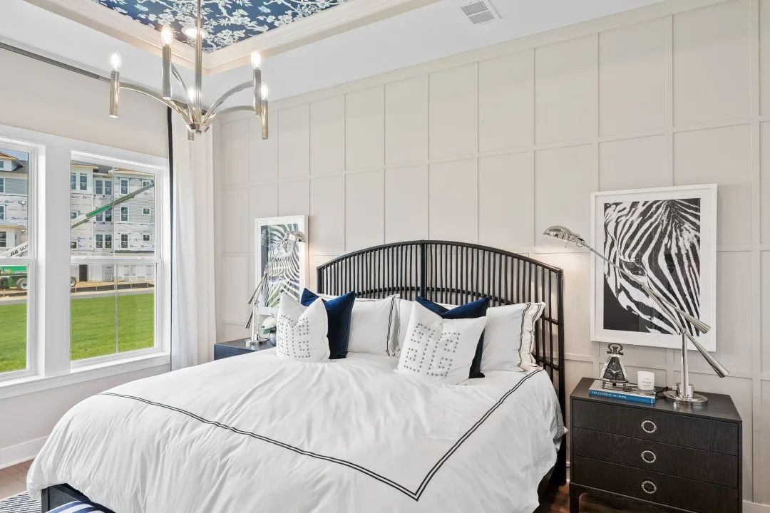 Primary suite with tray ceiling and decorative feature wall