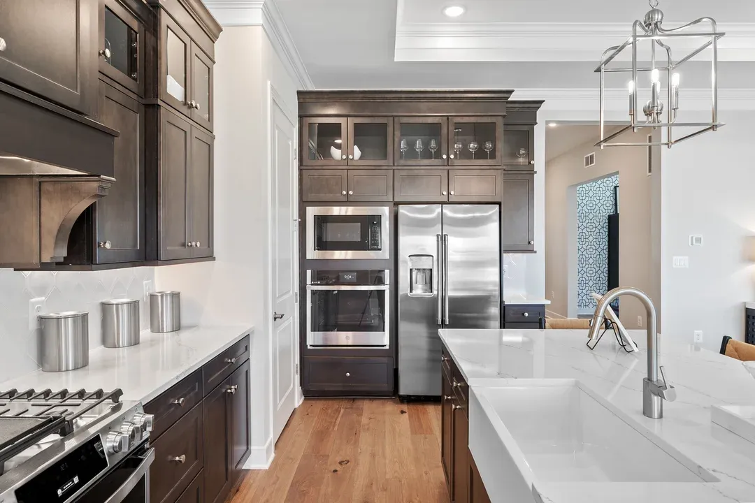 Kitchen with island, pendant lighting and glass-front upper cabinets